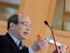 Neil Aronin usa blocchi Lego giganti per spiegare come i farmaci per il silenziamento genico potrebbero scomporsi in molecole più piccole con effetti collaterali propri. Crediti immagine: Lev Blumenstein per CHDI  